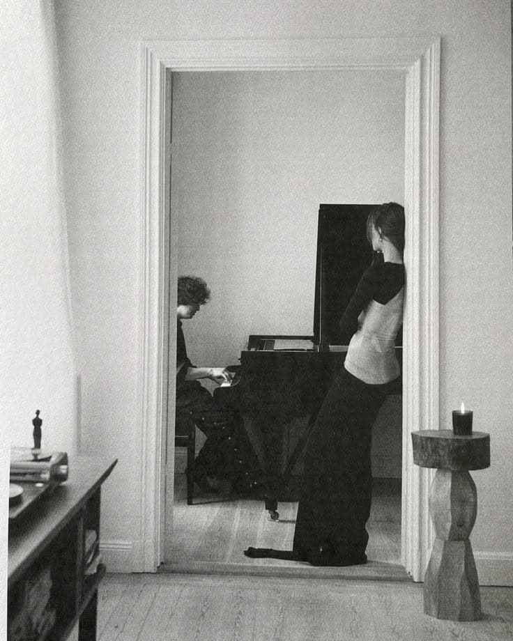 A pianist glimpsed through a doorway