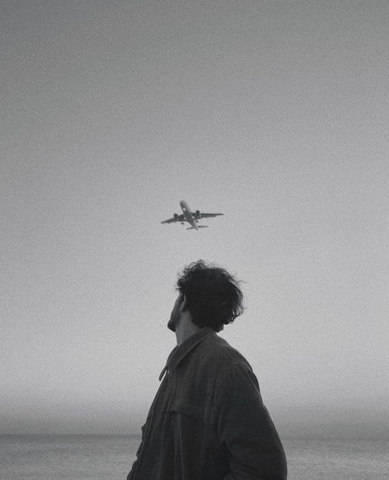 A person looking up at a plane overhead
